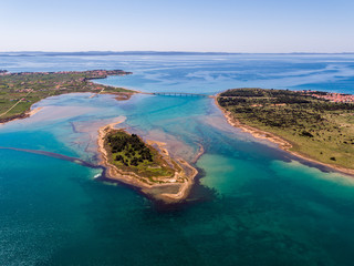 Aerial view of bridge to island Vir over the Adriatic sea with small island Viric in the foreground, Zadar county, Croatia