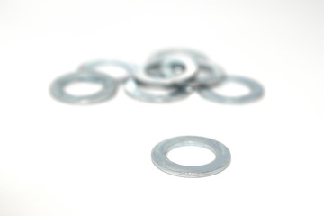 A few big industrial galvanized steel washers on white background