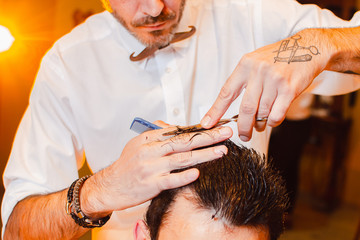 Barber shears the hair on her head with scissors. Haircut close-up. Barber Shop