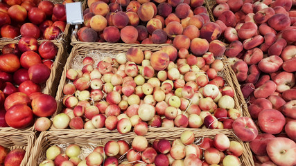 Nectarines and peaches in a wicker basket, displayed on the counter of the farm market