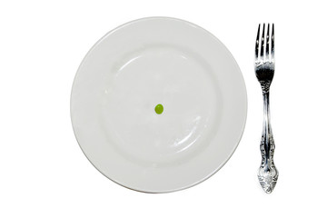 diet concept. one pea on an empty white plate with knife and fork