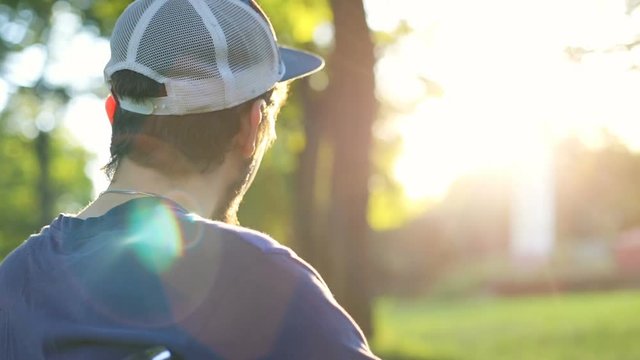unidentified young man in a wheelchair enjoying nature beauty and looking at sun setting over the horizon summer rest health care disease prevention physical recovery paralyzed body disability pension