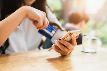 Online payment or mobile internet banking concept - Woman hands holding using smartphones for shopping and credit card making order transaction