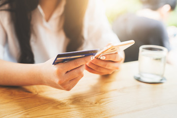 Online payment or mobile internet banking concept - Woman hands holding using smartphones for shopping and credit card making order transaction