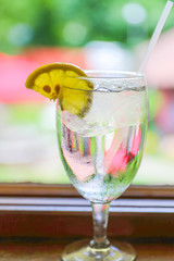Drink for hot summer days. Fresh lime and lemon lemonade in a glass on a wooden desk
