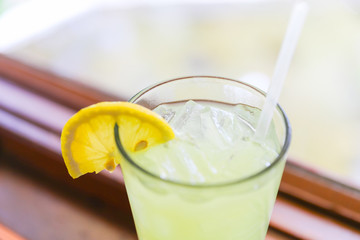 Drink for hot summer days. Fresh lime and lemon lemonade in a glass on a wooden desk