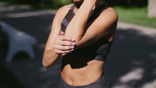 Woman massaging his left arm and elbow.