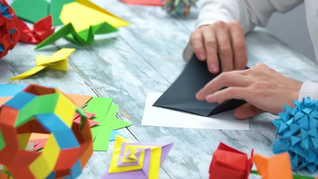 Making origami with black paper. Close up. Creating origami figures.