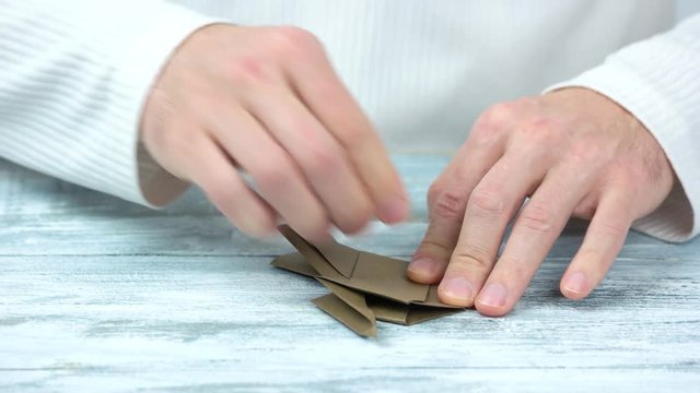 Creating origami motion. Close up, male caucasian hands.