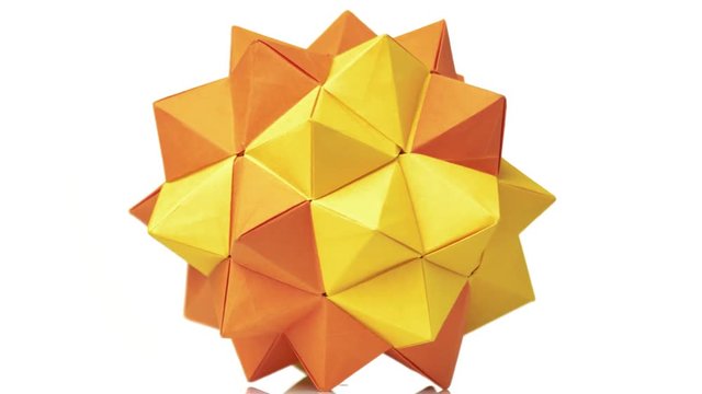 Orange origami transforming spiky ball. Bright isolated background.