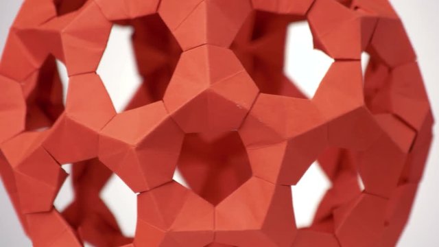 Close up red rotating modular origami. White background.