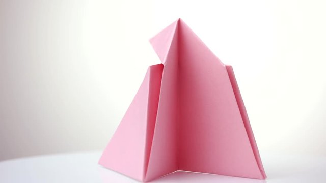 Pink origami snapper. White isolated background.