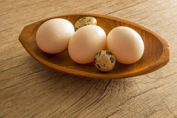 Fresh farm eggs  in a bowl on a wooden rustic background