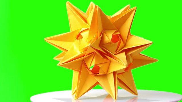 Yellow origami spiky ball exposition. Green hromakey background for keying.