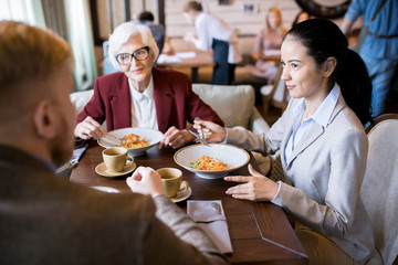Business partners sitting at the table and communicating during business lunch