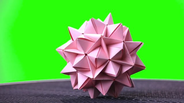 Pink origami spiky ball. Green hromakey background for keying.