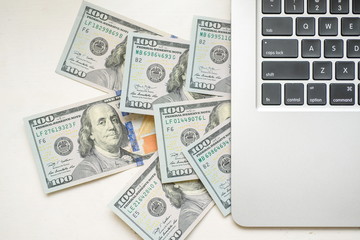 Dollar bills appearing from above the mining laptop