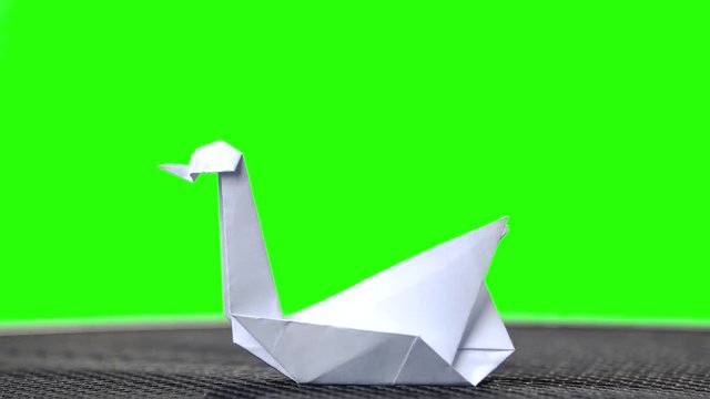 White paper origami swan. Green hromakey background for keying.