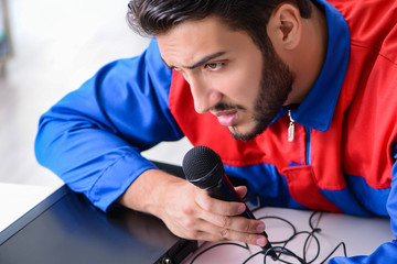 Man repairman repairing dvd player at service center