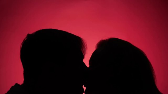 color background. 4k, slow motion. shadow of a man. couple, man and woman kissing
