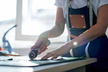 Close-up of leather master demonstrating leather cutting process
