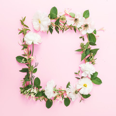 Frame of white flowers and leaves on pink pastel background. Flat lay, top view. Floral pattern