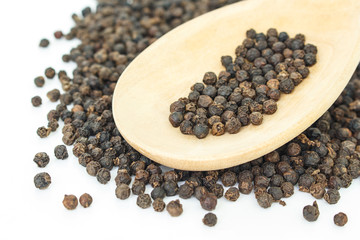 peppercorns in spoon heap on white background.