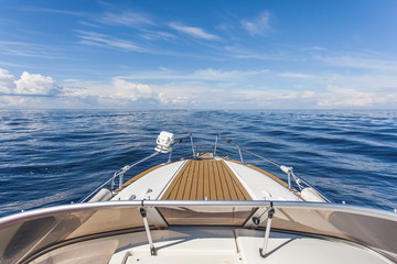 motor Boat sails on the water surface of the lake against the background of clouds