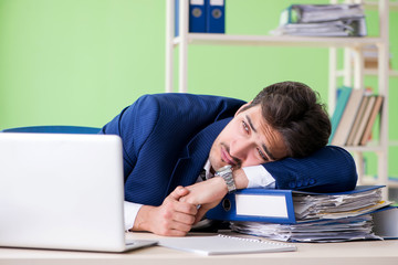 Businessman unhappy with excessive work sitting in the office 