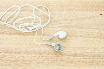 earbuds or earphones on wooden background