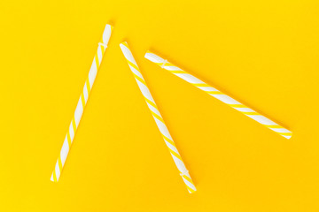 yellow striped straws on pink background