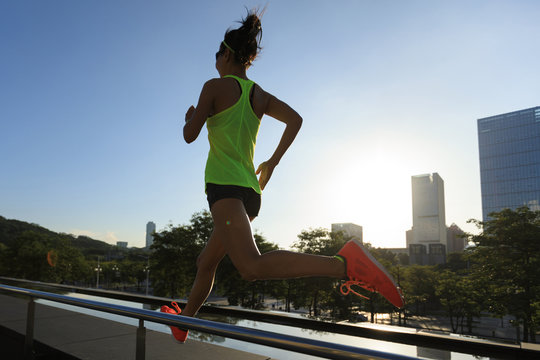 Healthy lifestyle fitness woman runner running at sunrise city