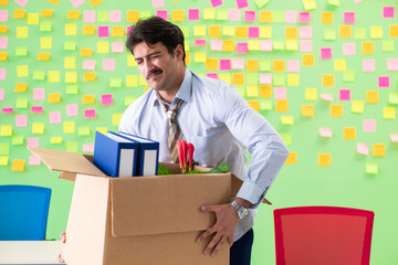 Man collecting his stuff after redundancy in the office with man