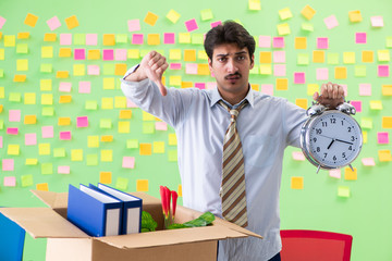 Man collecting his stuff after redundancy in the office with man