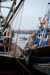 Agadir / Morocco - JUN 20 2014: african fishing boats docked in a harbor next to the wholesale...