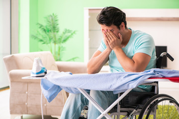 Disabled man on wheelchair ironing clothing