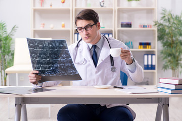 Young doctor looking at x-ray images in clinic