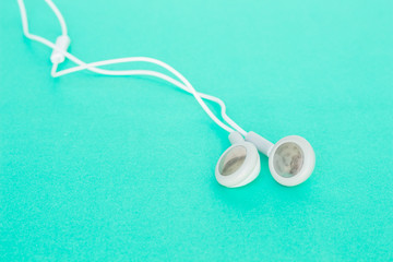 earbuds or earphones on green background