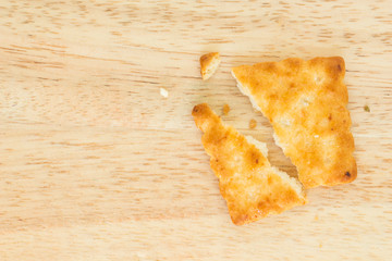 Crackers broken in half on wooden background.