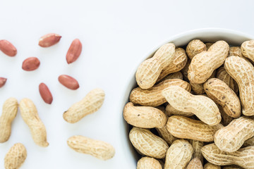 peanut pile in white bowl top view on white background