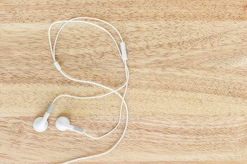 earbuds or earphones on wood background
