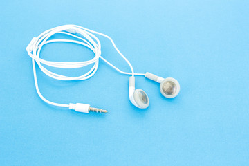 earbuds or earphones on blue background