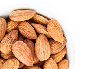 almonds in white bowl top view on white background.