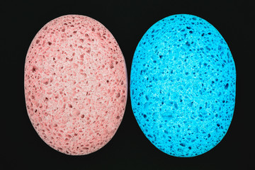 Pink and blue sponge isolated on black background surface