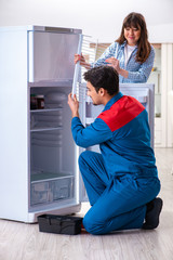 Fototapeta na wymiar Man repairing fridge with customer