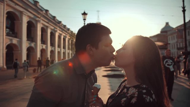 Happiness couple with ice cream under sunlight at evening sunset. They joking, smiling, laughing and having fun, kissing. Slow motion.