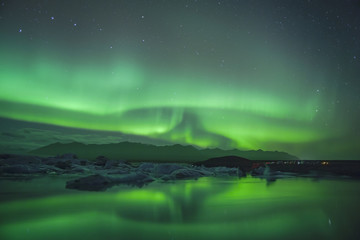 Obraz na płótnie Canvas Northern Lights over glacier lagoon in Iceland. Up north northern lights show.