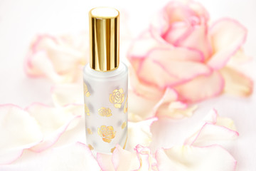 a bottle of perfume on the background of rose petals