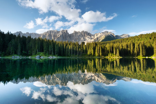 Mountains and forest reflection on the water surface. Natural landscape in the Dolomites Alps in the Italy