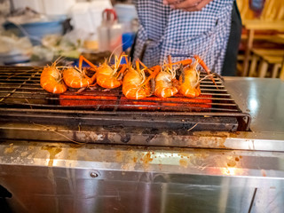 Grilled giant river prawn or big shrimp on stove with selective focus.A recommended menu for tourists when they come to Thailand. The prawn is served with spicy seafood sauce.